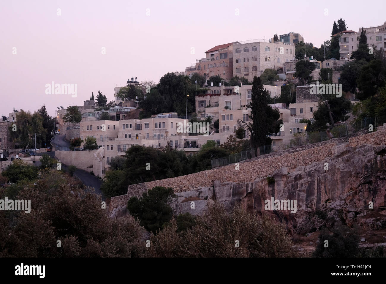 View at twilight of Abu Tor a mixed Jewish and Arab neighborhood located over valley of Hinnom the modern name for the biblical Gehenna or Gehinnom valley surrounding Jerusalem's Old City, Israel Stock Photo