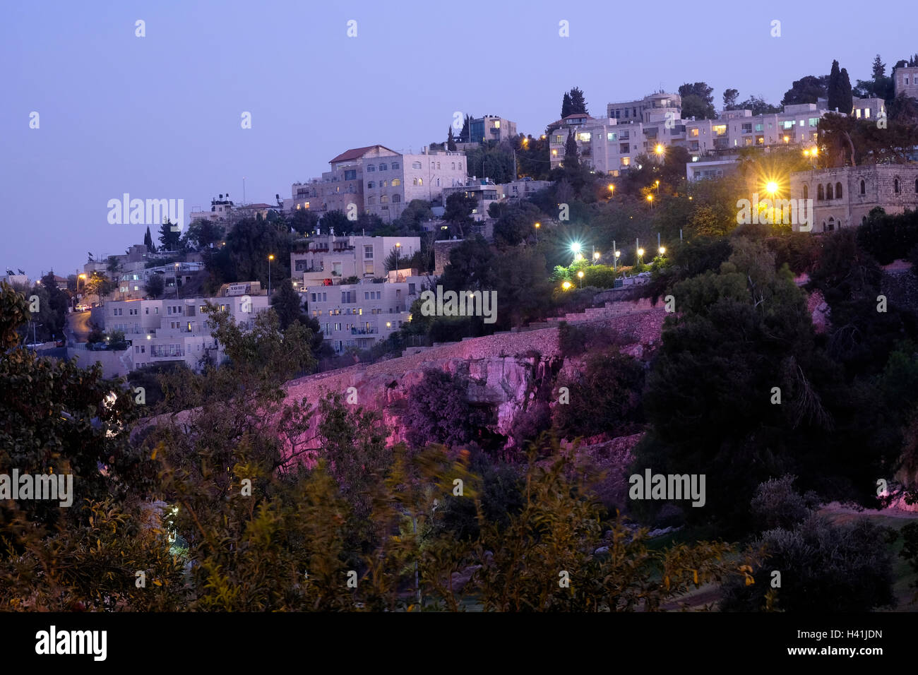View at twilight toward Abu Tor a mixed Jewish and Arab neighborhood located over valley of Hinnom the modern name for the biblical Gehenna or Gehinnom valley surrounding Jerusalem's Old City, Israel Stock Photo