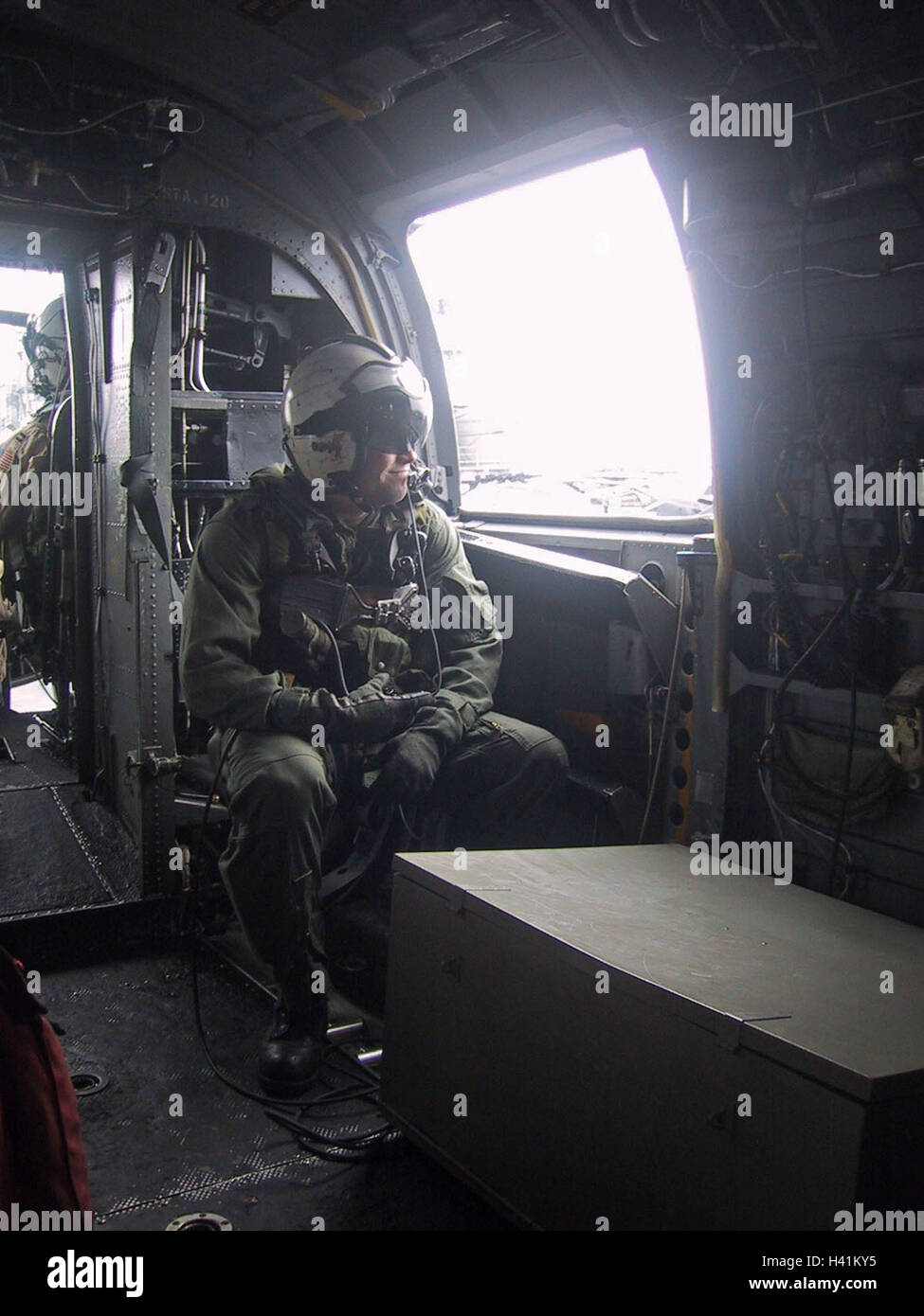 28th January 2003 During Operation Enduring Freedom, a naval aircrewman sits at the side door of a U.S. Navy Sea Knight helicopter. Stock Photo