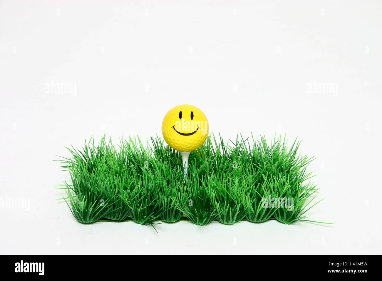 Art lawns, tea, golf ball, Smiley,   Lawns, art grass, grass, artificially, ball mini golf reduction, lawn surface, Indoor, T, sport, golf, golf game, gulves, practicing, training, face, smiles, cleverly, kindly, childishly, concept, studio Stock Photo