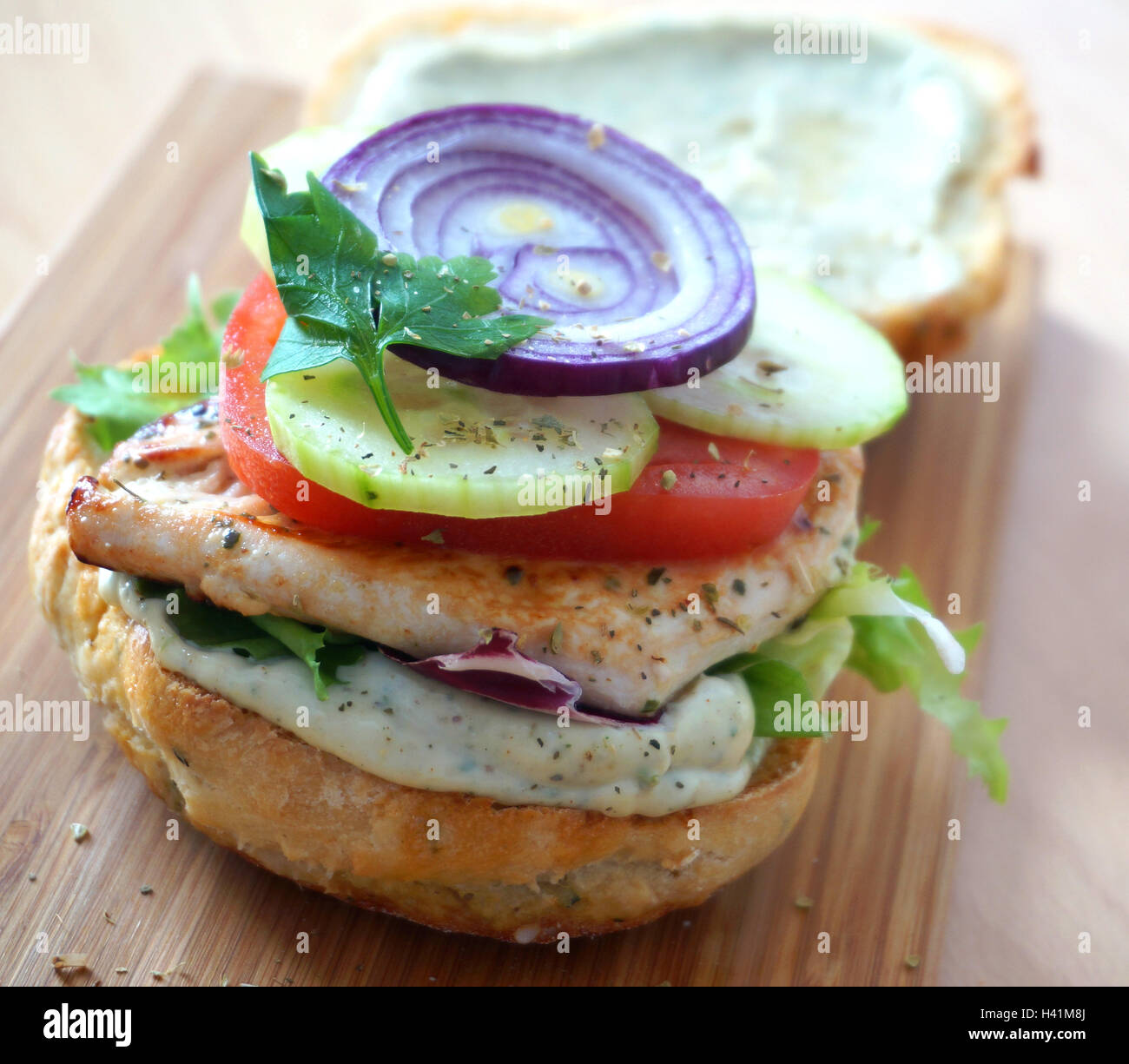 Delicious burger with chicken and vegetables. Stock Photo