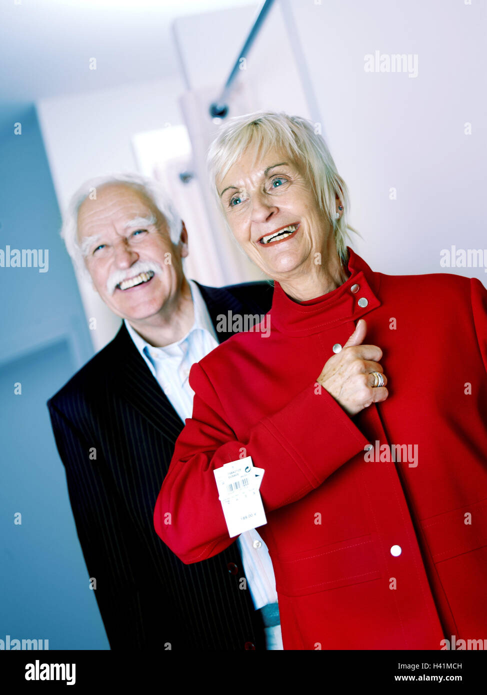 Boutique, Senior couple, shopping tour, woman, jacket red, try, select, together, happy, 60-70 years, married couples, married couple, couple, senior citizens, pensioners, retirement age, old person, Best Age, shopping, shopping, business, ladies wear, se Stock Photo