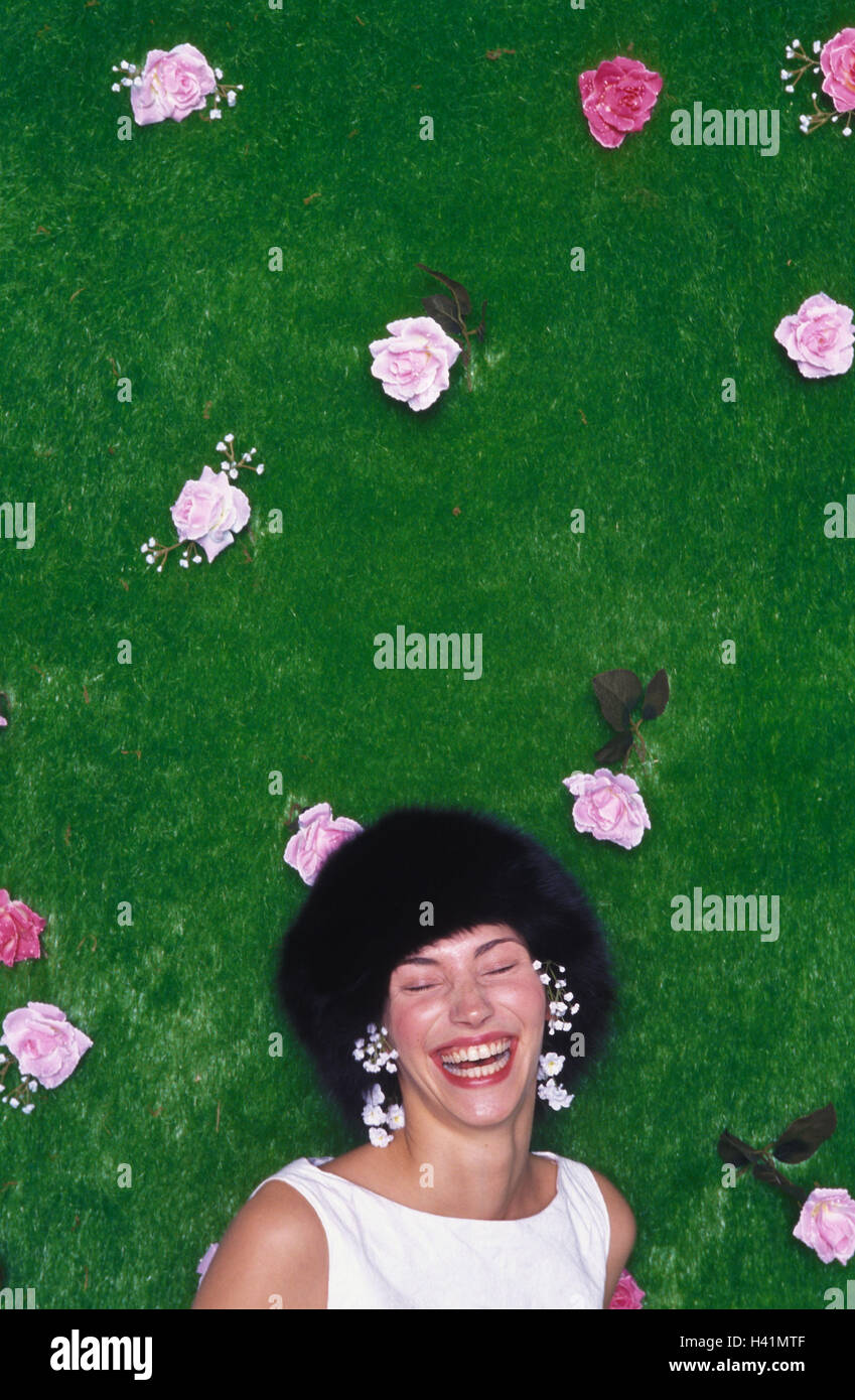 Woman, young, laugh, silk flowers, wall hanging, art turf, 20-30 years, funnily, cheerfulness, cheerfulness, joy, happy, summery, flowers, blossoms, turfs, artificially, wig, care, headgear, fur cap, exuberance, fun, humor, amusement, amuse, roses Stock Photo