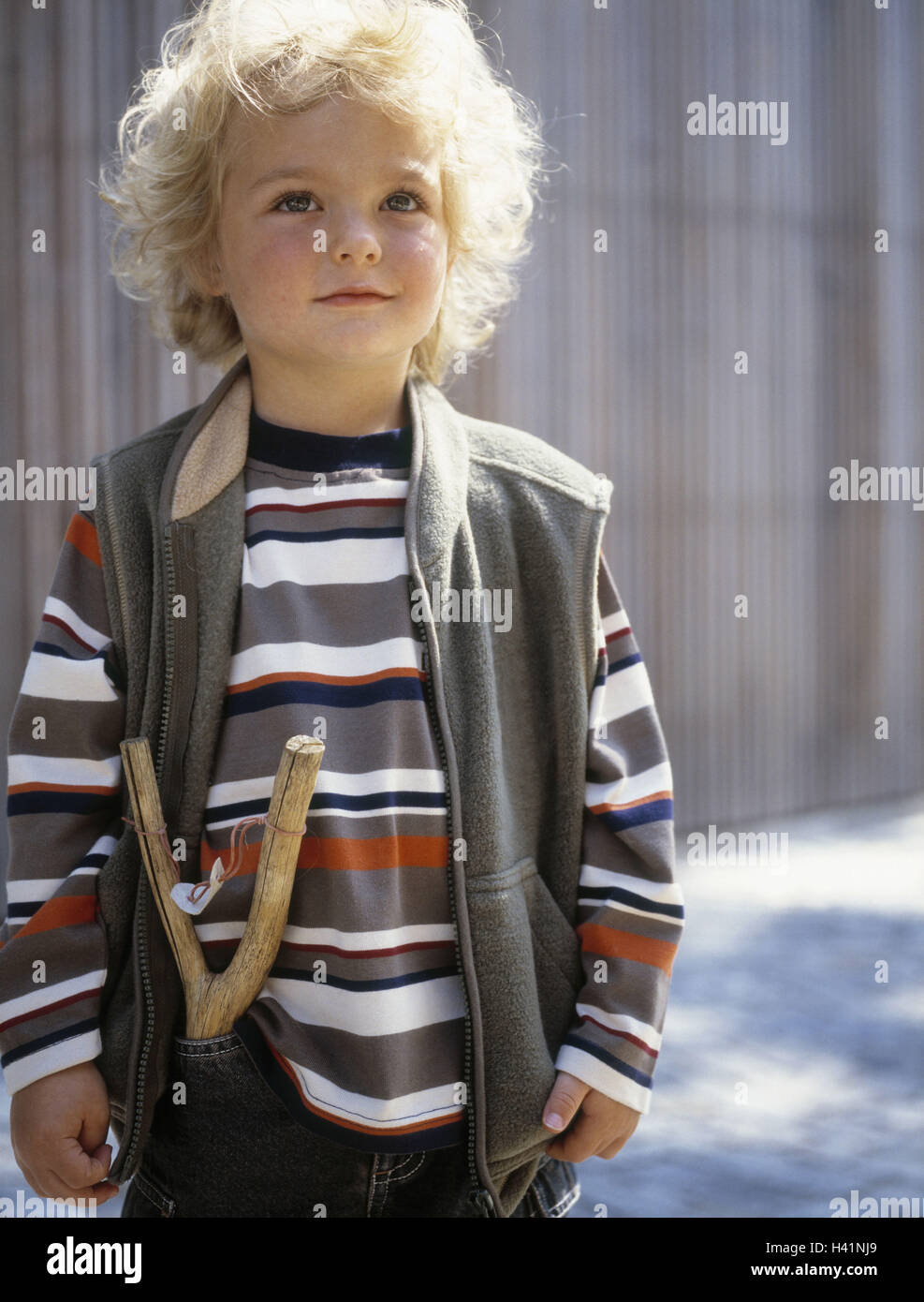 Boy, trouser pocket, catapult, half portrait, child portrait, child, infant, 3 - 5 years, blond, curls, wavy, childhood, cheeky, louse's jack, rogue, clothes, autumnally, outside, stand Stock Photo