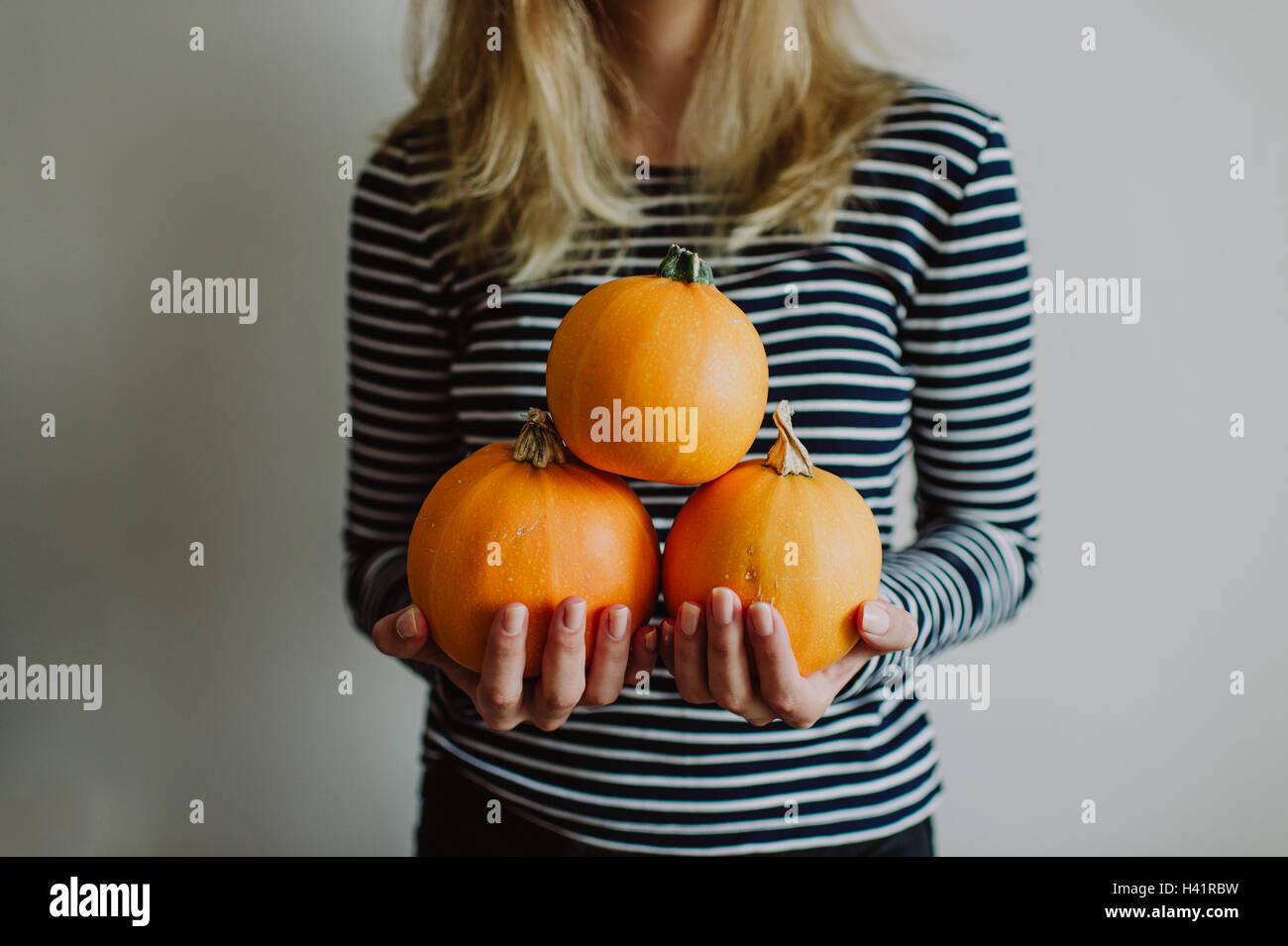Woman holding three pumpkins Stock Photo