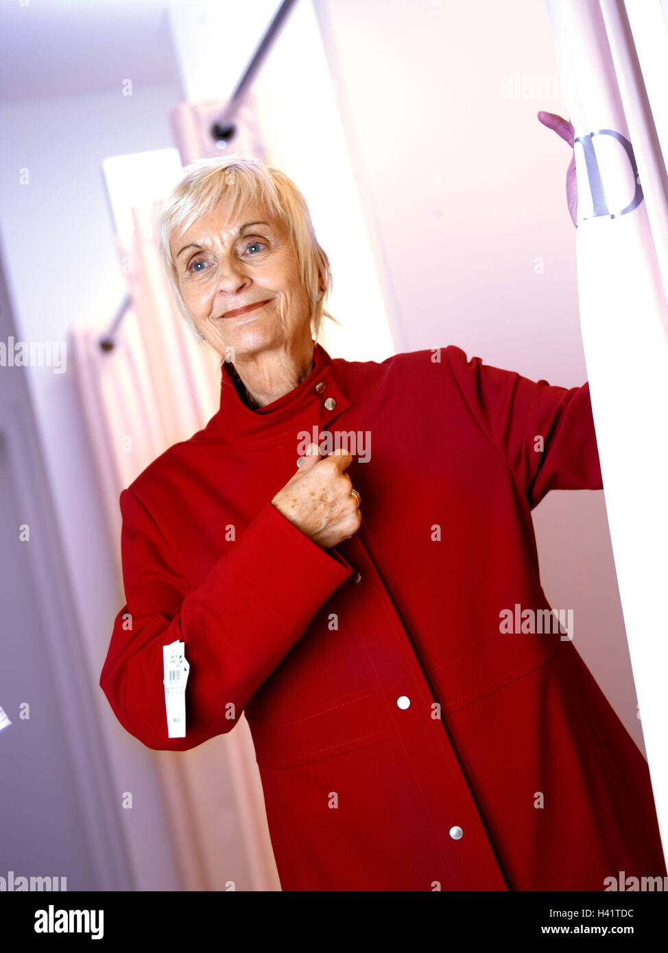 Boutique, senior, woman, jacket red, try, smile, half portrait, 60-70 years, woman, pensioner, retirement age, old person, Best Age, actively, fit, shopping, shopping, business, shopping tour, business, ladies wear, select, try on, choice, select, shoppin Stock Photo