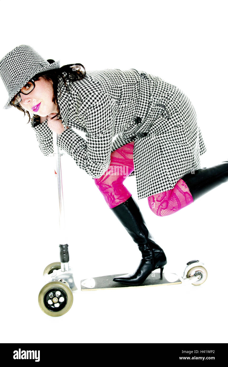 Woman, young, hat, coat, springhalt patterns,  Boots, scooters, drive, at the side  Series, 20-30 years, glasses, glasses bearer, brunette, made up, lips, pink, strikingly, tights, stockings, scrutinized, clothing, autumnal, headgear trenchcoat style fash Stock Photo