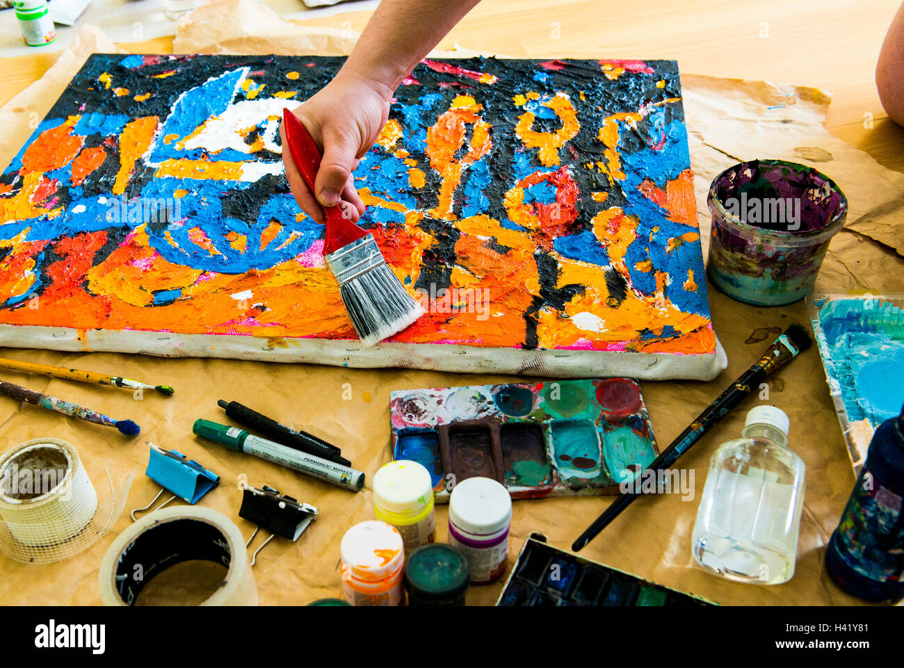 Hand brushing paintbrush over canvas painting Stock Photo - Alamy