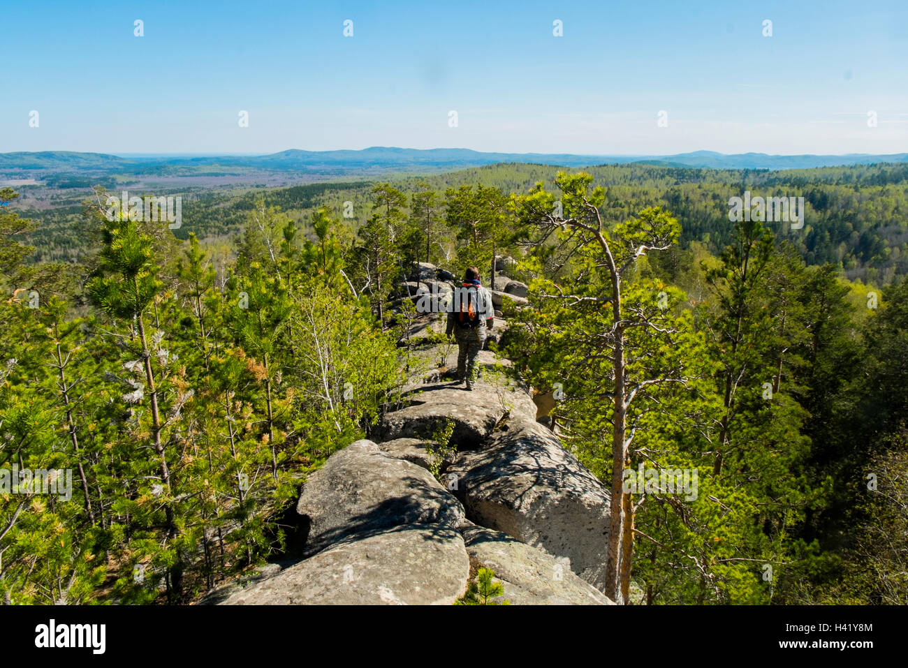 Caucasian man walking on mountain rock admiring scenic view Stock Photo