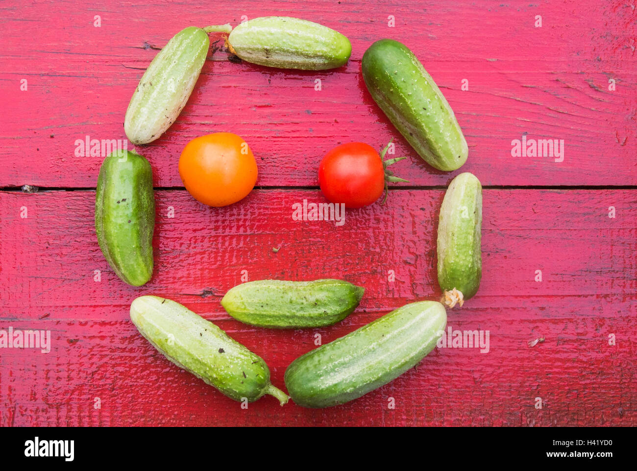 Cucumbers and tomatoes arranged in smiley face Stock Photo