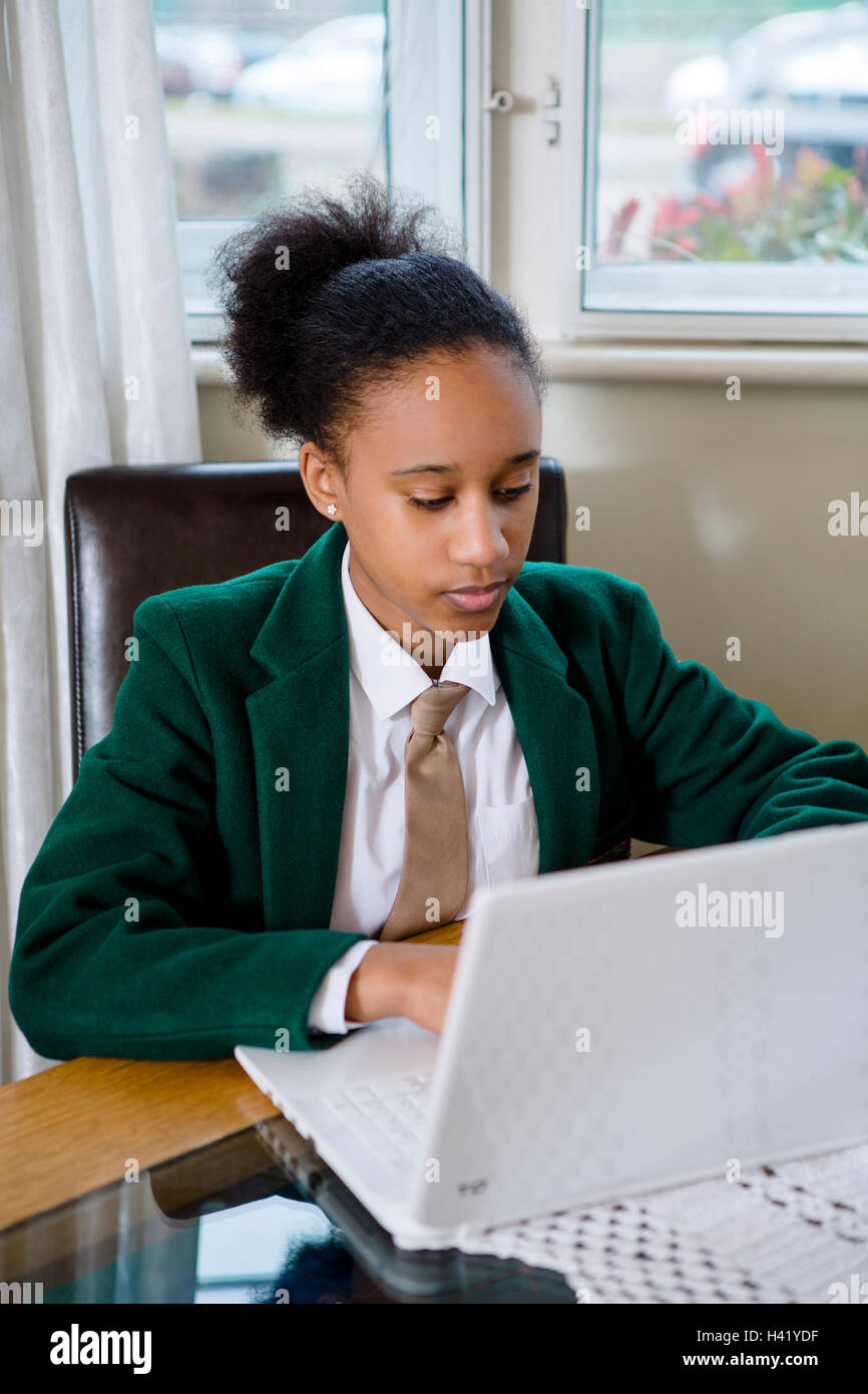 Black girl wearing school uniform using laptop Stock Photo