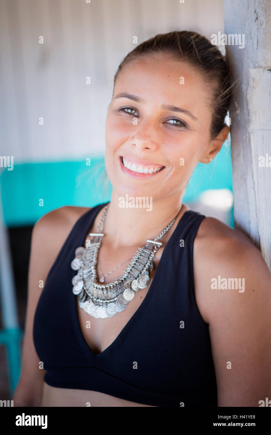 Smiling hispanic woman wearing necklace and bikini Stock Photo