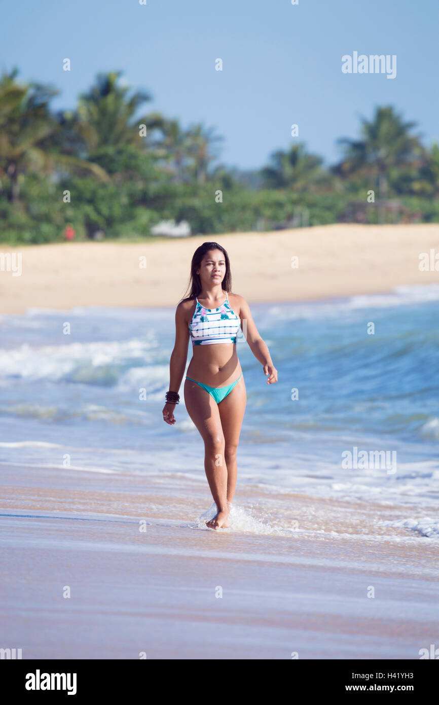 Mixed Race girl walking on beach Stock Photo