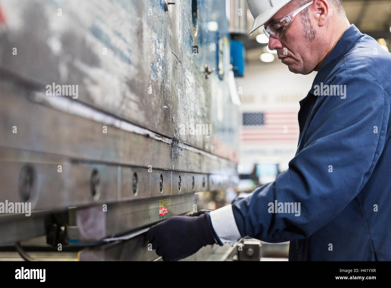Hispanic worker fabricating metal in factory Stock Photo