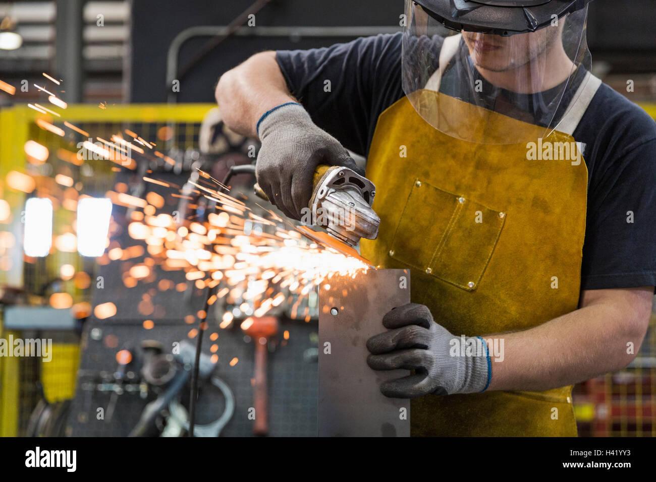 Caucasian worker grinding metal in factory Stock Photo