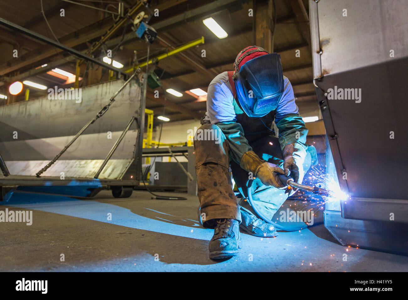 Caucasian man welding metal in factory Stock Photo