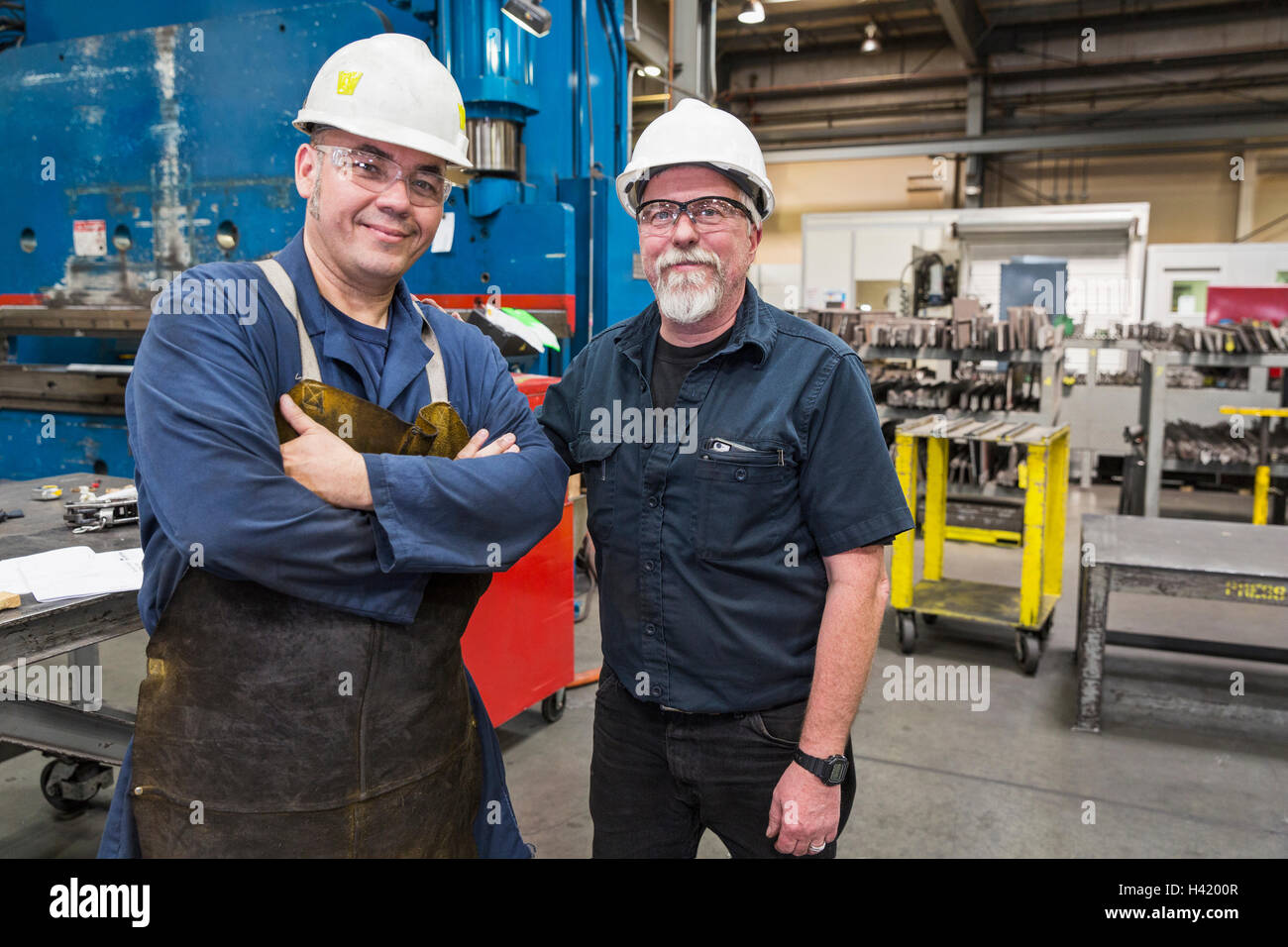 Smiling workers posing in factory Stock Photo
