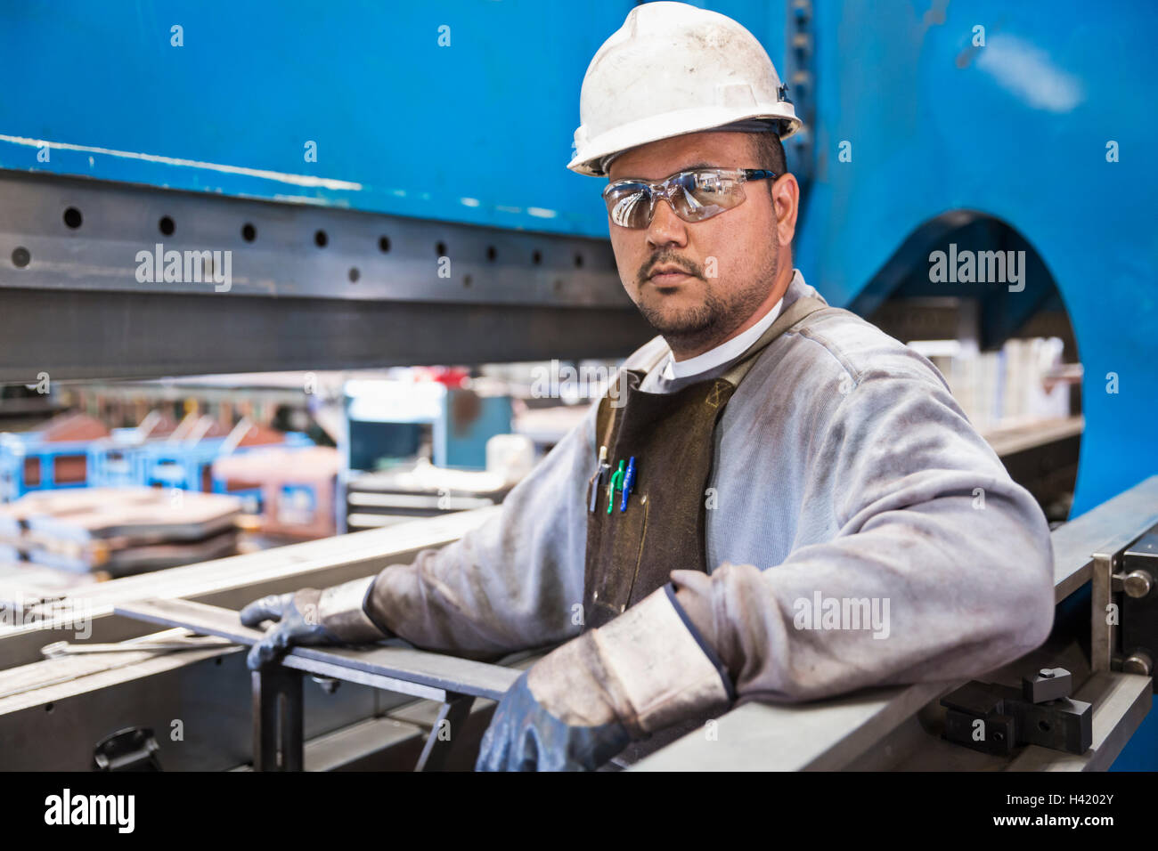 Pacific Islander worker posing in factory Stock Photo