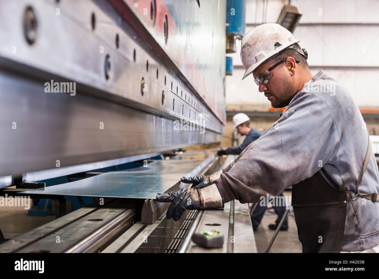 Workers fabricating metal in factory Stock Photo