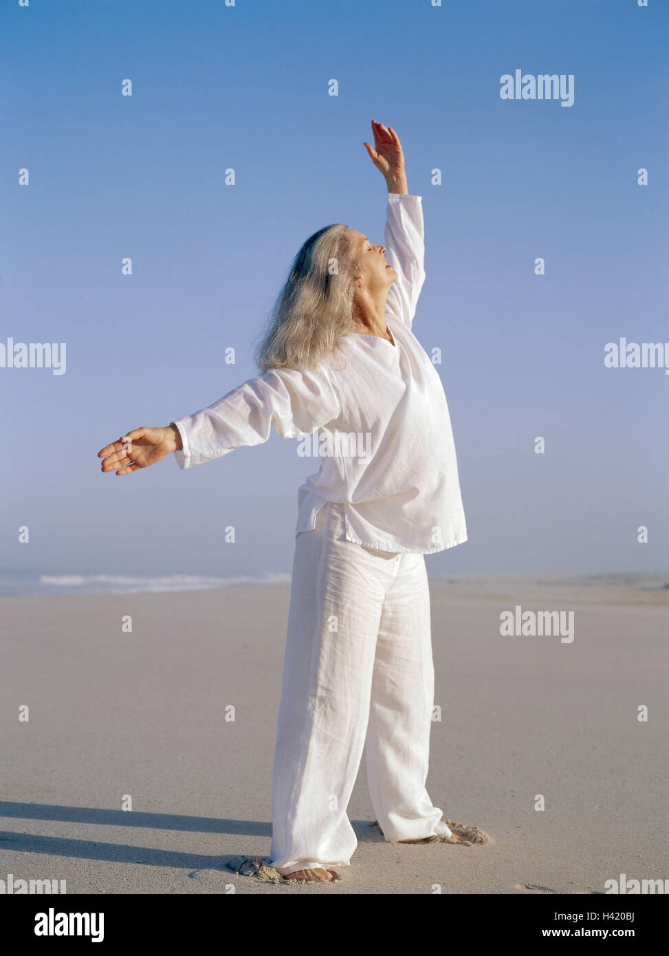 Sandy beach, woman, Tai-Chi, Best Age, 50-60 years, beach, sea, leisure time, hobby, practise, meditative, motion, motion sequences, exercises, slowly, fluently, shadow speakers, 'Free Flow Movement', balance, activity, body consciousness, meditation, Tai Stock Photo