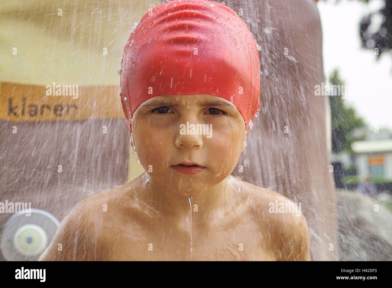 Outdoor swimming pool, douche, boy, bathing cap, red, portrait,  swimming-pool, outside douches, child portrait, child, infant, 3 - 5 years,  bathing cap, wash, give of a shower, water, jet water, drops water,