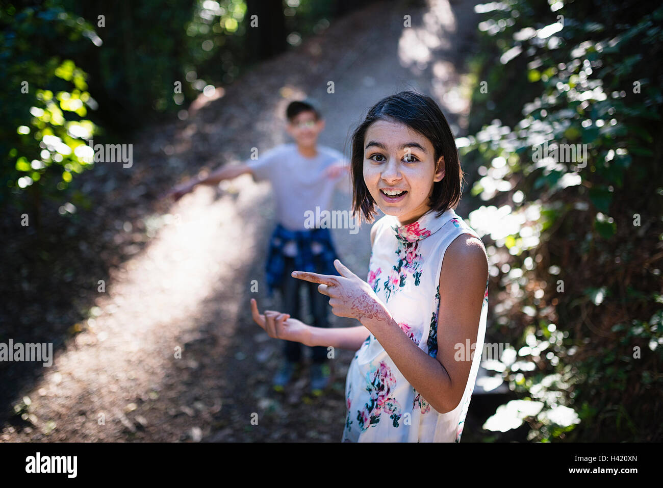 Mixed Race brother and sister on sunny path Stock Photo