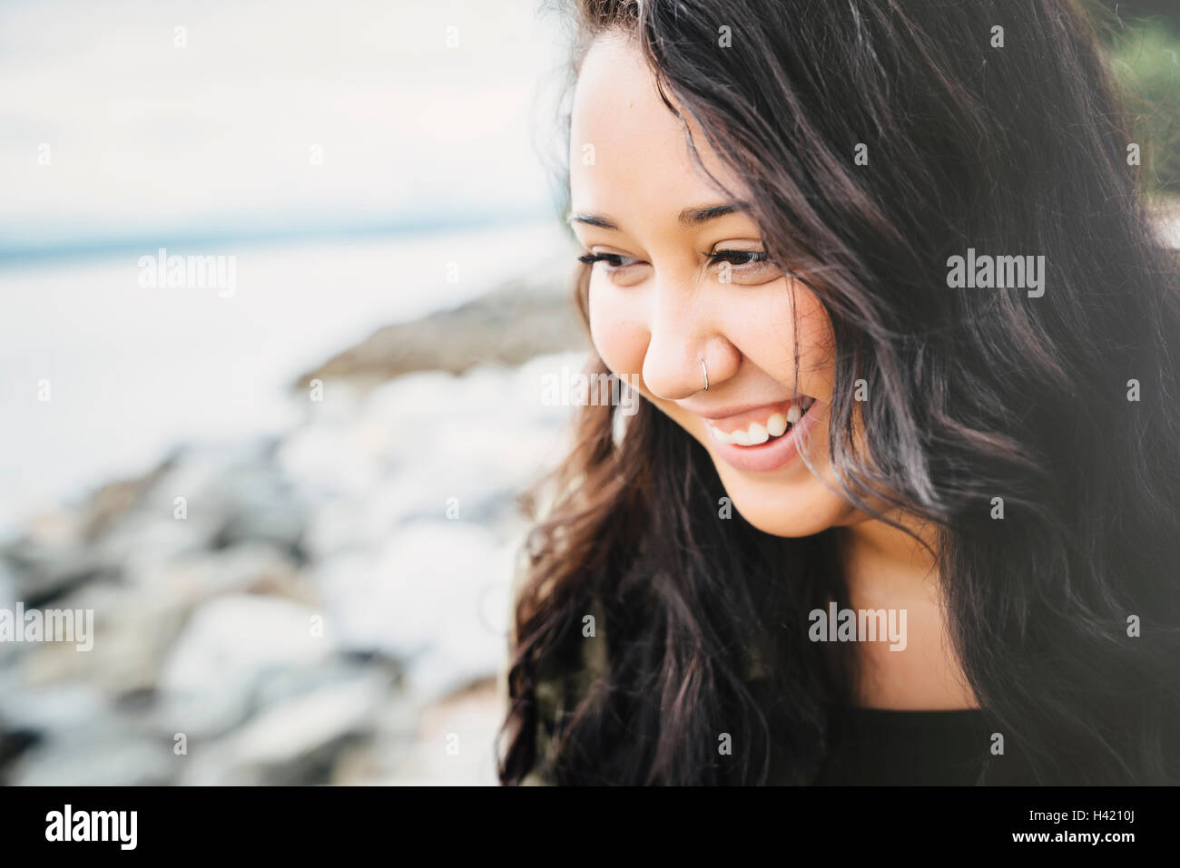 Smiling Mixed Race woman at ocean Stock Photo