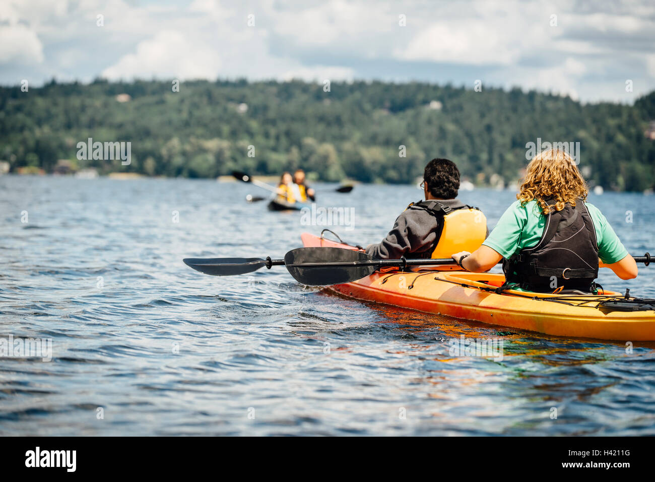 Man and woman holding paddles in kayak Stock Photo