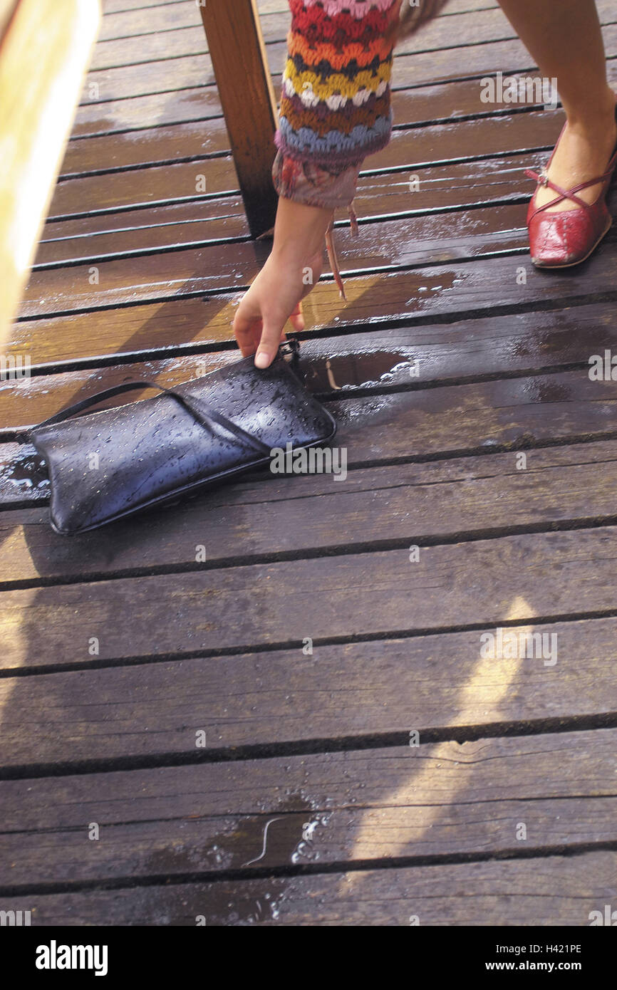 Woman, detail, wooden floor, handbag, lift, bad luck, lost, floor, wet, rains, water, outside, pouch, arm, reach, bend down Stock Photo