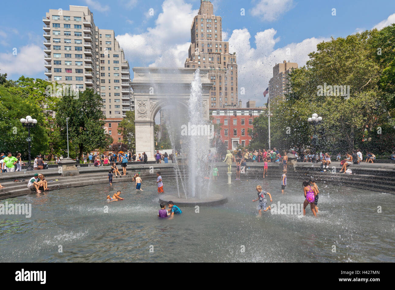 Washington Square Park Arch in New York City and people playing in the water fountain. Stock Photo