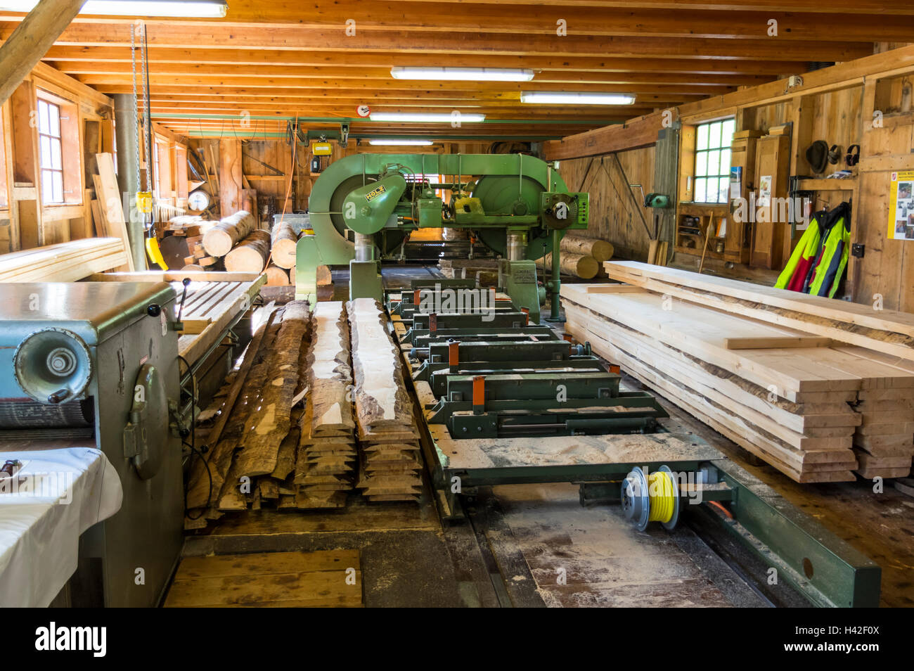 Sawmill with sawed wood planks and machinery. Stock Photo