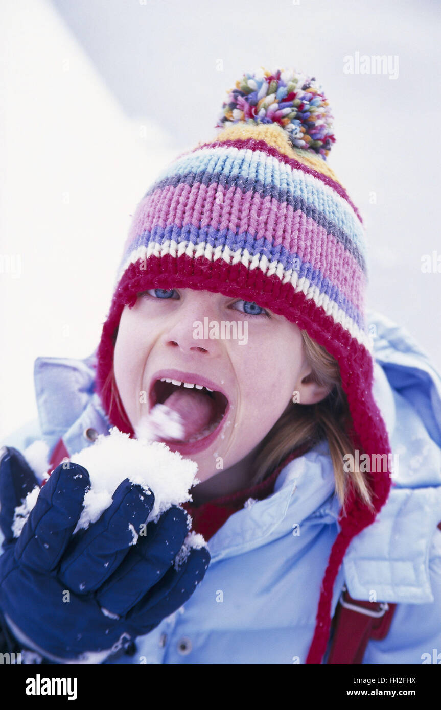 Girls, cheeky, snow, eat, winter clothes, portrait, child portrait, child, 6 years, season, winter, wintry, enjoy, snow fun, winter fun, happy, childhood, cheerfulness, taste, experience, experience, cap, headgear, poodle's cap Stock Photo