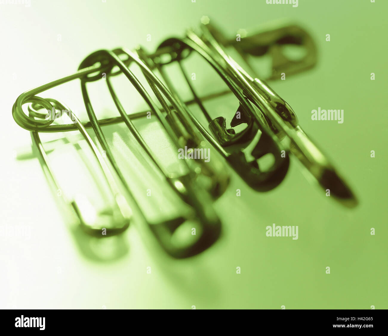 Safety pins sewing, manual labour, thread implement, household articles, household, haberdashery, thread accessories, mounting, cohesion, backup, temporarily, provisionally, as of a makeshift, several, Still life, product photography, green Stock Photo