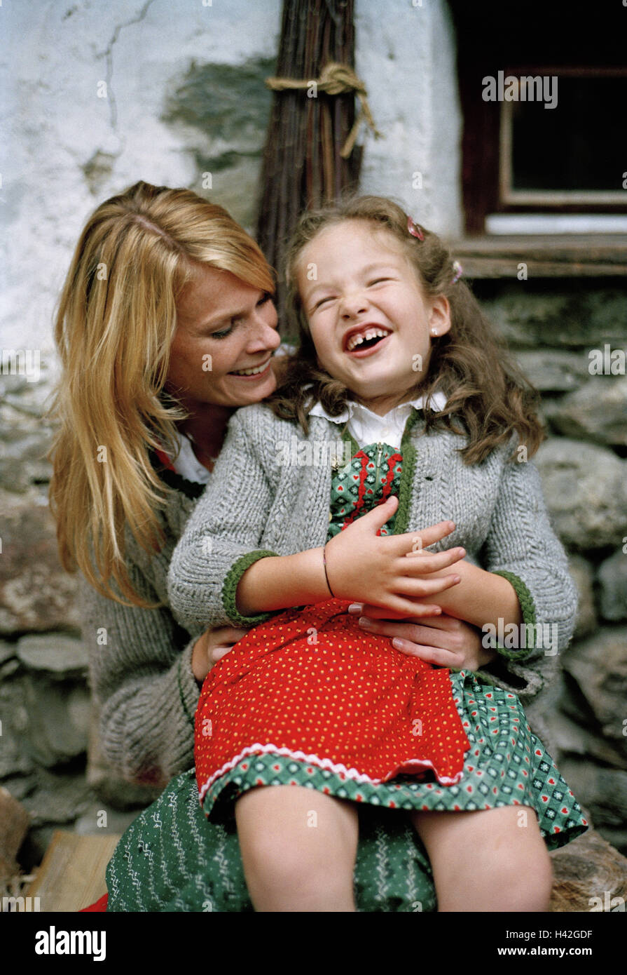 Mother, daughter, Almhütte, outside,  cheerfully, laughs,   Series, woman, 20-30 years, child, girls, 4-8 years, Dirndl, official dress, cottage, Alm, rustic, simplicity, vacation, individual vacation, summers, fun, jokes, happily, sits freely, lap,, Stock Photo