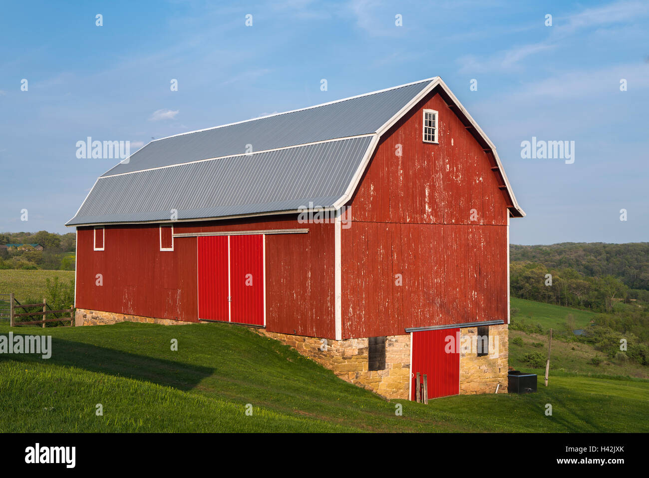 Iowa County, Wisconsin: Red barn, rolling hills under blue sky Stock Photo