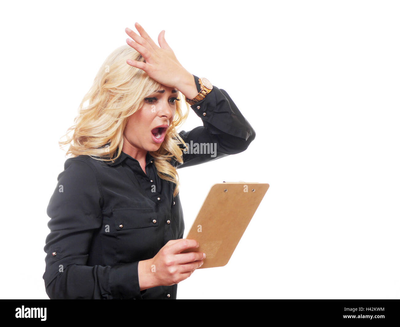 A attractive blond haired business woman is shocked as she reads a clipboard Stock Photo