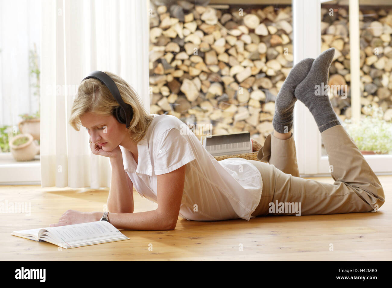 Woman, young, earphones, book, read, lie, floor, flat, room, hobby, person, literature, textbook, foreign language, learn, linguistic exchange rate, languages, music, hear, recreation, rest, relax, leisure time, whole body, lifestyle, inside, Stock Photo