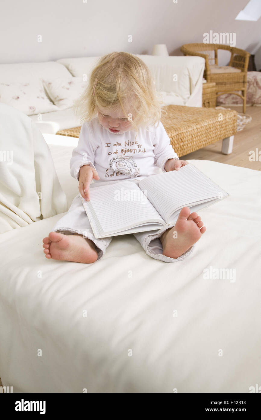 Living rooms, couch, toddler, girls, sit, views, book, portrait, apartment, people, child, 1-2 years, blond, barefoot, however, child-book, reads, pages, interest, curiosity, quite-bodies, childhood, at home, interior, Stock Photo