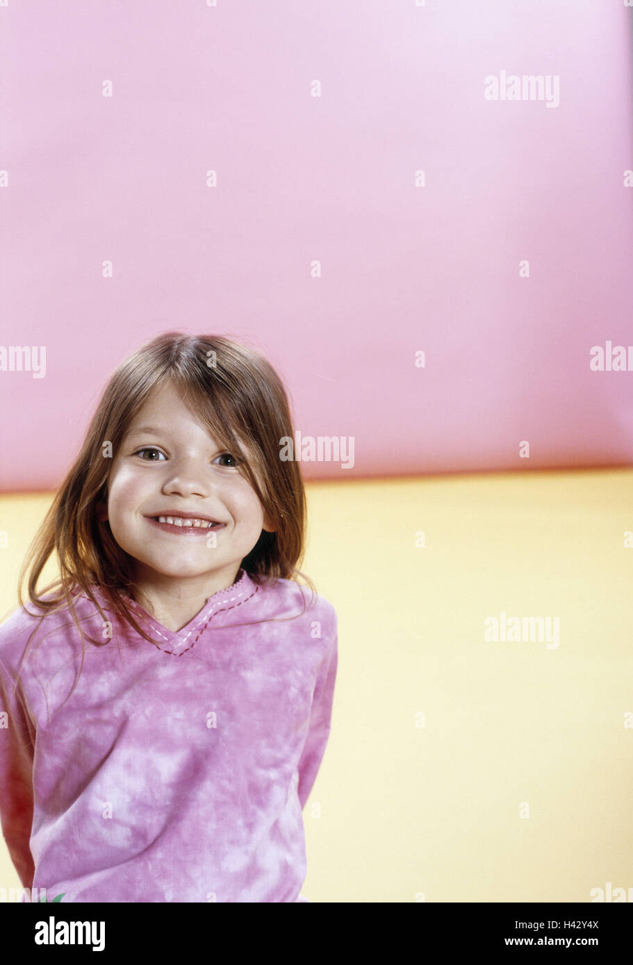 Girls, smiles, floor, sits,  Portrait  Child portrait, child, toddler, 4-6 years, long-haired, gaze camera, childhood, happily, expression, happiness, indoors, studio, background yellow-pink Stock Photo