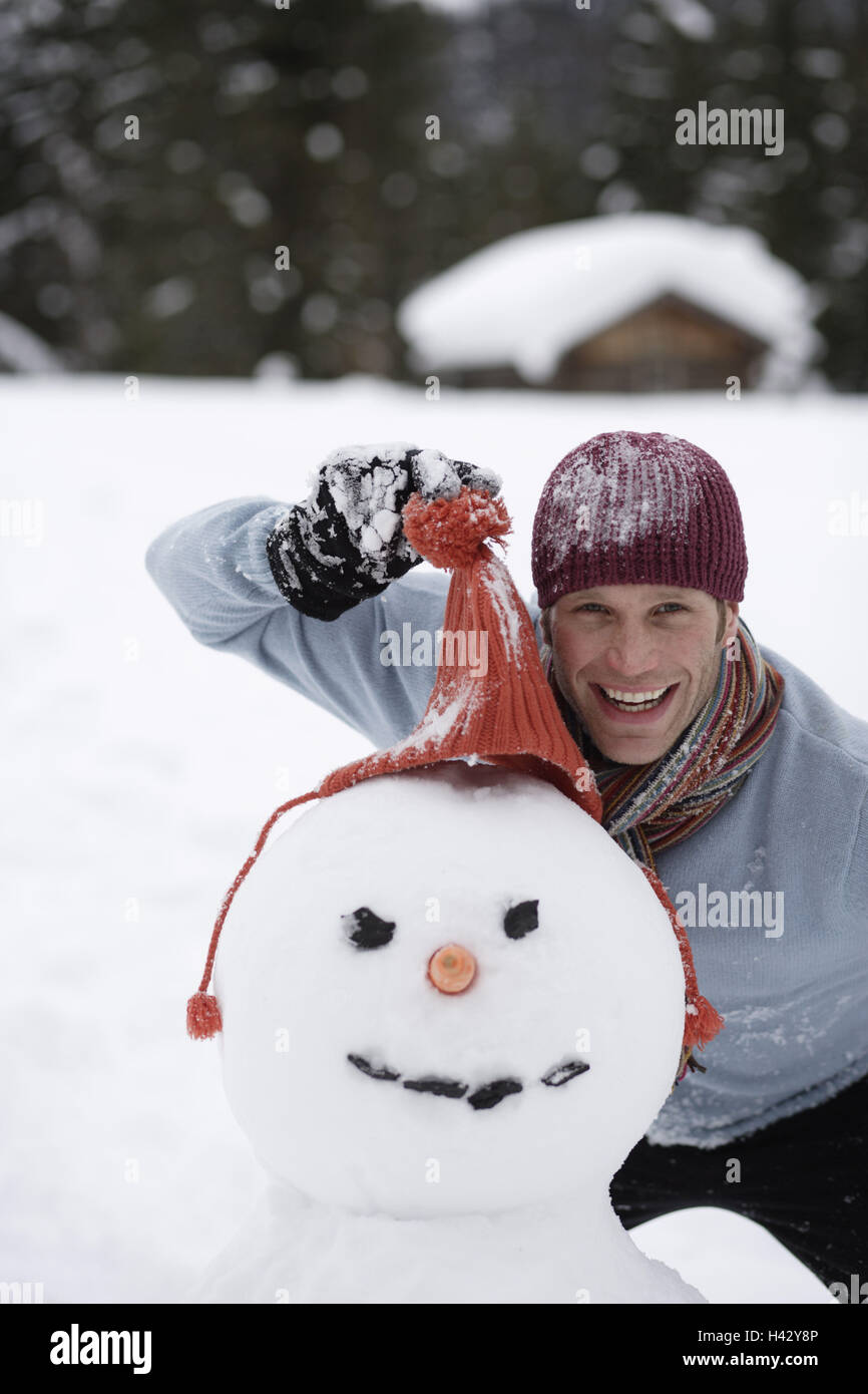 Man, laughs, snowman, gesture,  Cap, portrait,  Series, men's portrait, 20-30 years, young, nicely, sympathetically, snow, vacation, leisure time, fun, zest for life, happiness, clothing, winter clothing, scarf, snow fun, in the winter passport, outside, winters, happily, merrily, humor, cleverly Stock Photo