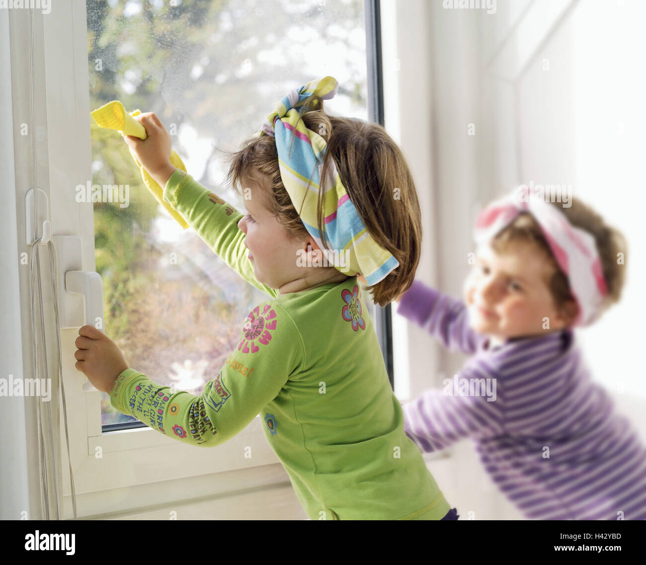 Children, girls, windows clean, detail, twins 3 years, sisters, siblings, friends, friendship, childhood, housecleaning, window plaster, 'cleaning devil', cloths, fungus cloths, windowpane, clean, dry, together, cohesion, motivation, ambition, inside, Ti1 Stock Photo