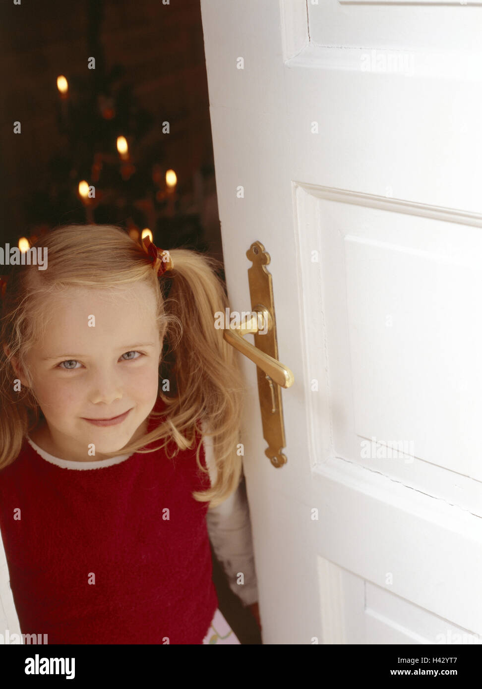Christmas,Christmas Eve,Christmas tree,blond,child,childhood,door,expectation,girl,lighthearted,living room,open,prejoy,smile,tension,x-mas,yule tide Stock Photo