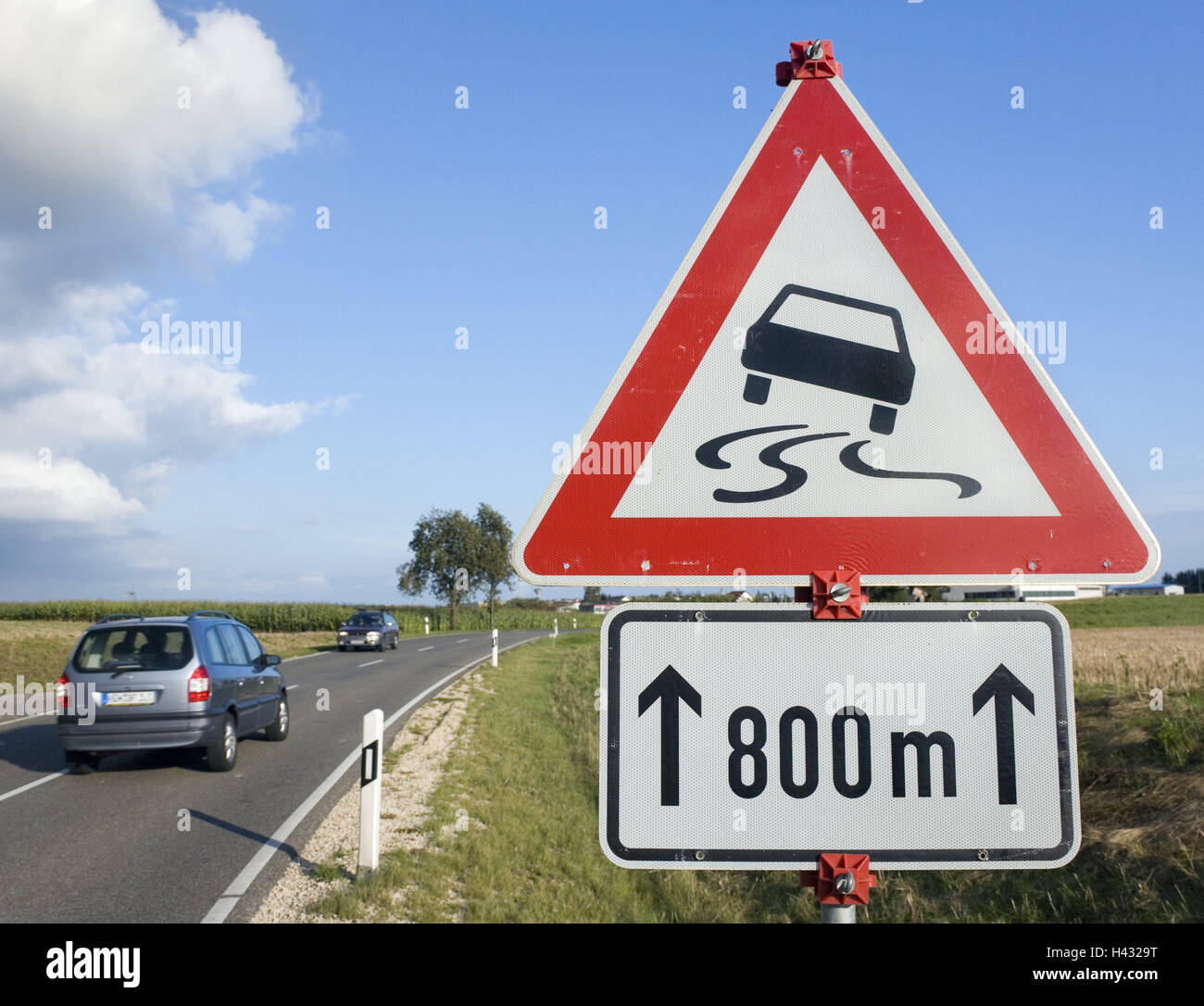 Country road, road sign, warning, slick road, warning tip, street, traffic, cars, passenger car, traffic, danger collision, traffic sign, sign, danger sign, red, attention, outside, deserted, Stock Photo