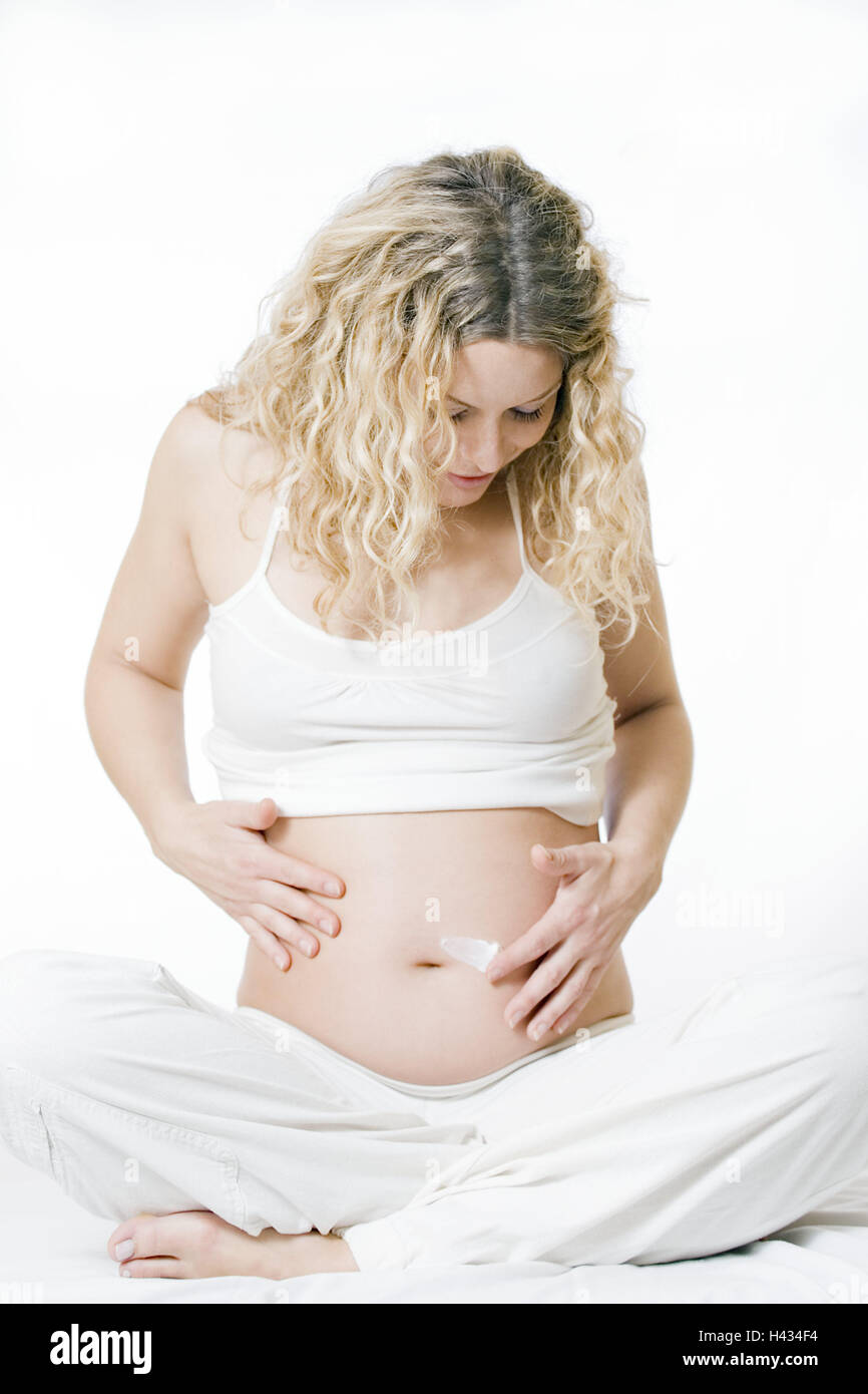 Woman, young, blond, pregnant, touch, abdomen, cream, cross legged, model released, people, pregnant, gestation, long-haired, curls, younger generation, child wish, planned child, feel, feel, baby abdomen, well-being, inside, leisure time, care, shell care, litheness, prophylaxis, gestation films, Stock Photo