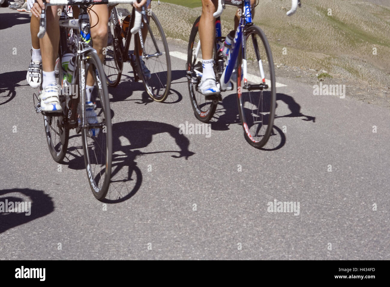 Street, racing cyclist, go, uphill, detail, no model release, France, racing wheels, bicycles, cycling, sport, bicycle driving, motion, feet, bicycle shoes, radian shoes, step, strain, hobby, leisure time, perseverance, condition, person, group, nature, sunshine, shade, Stock Photo