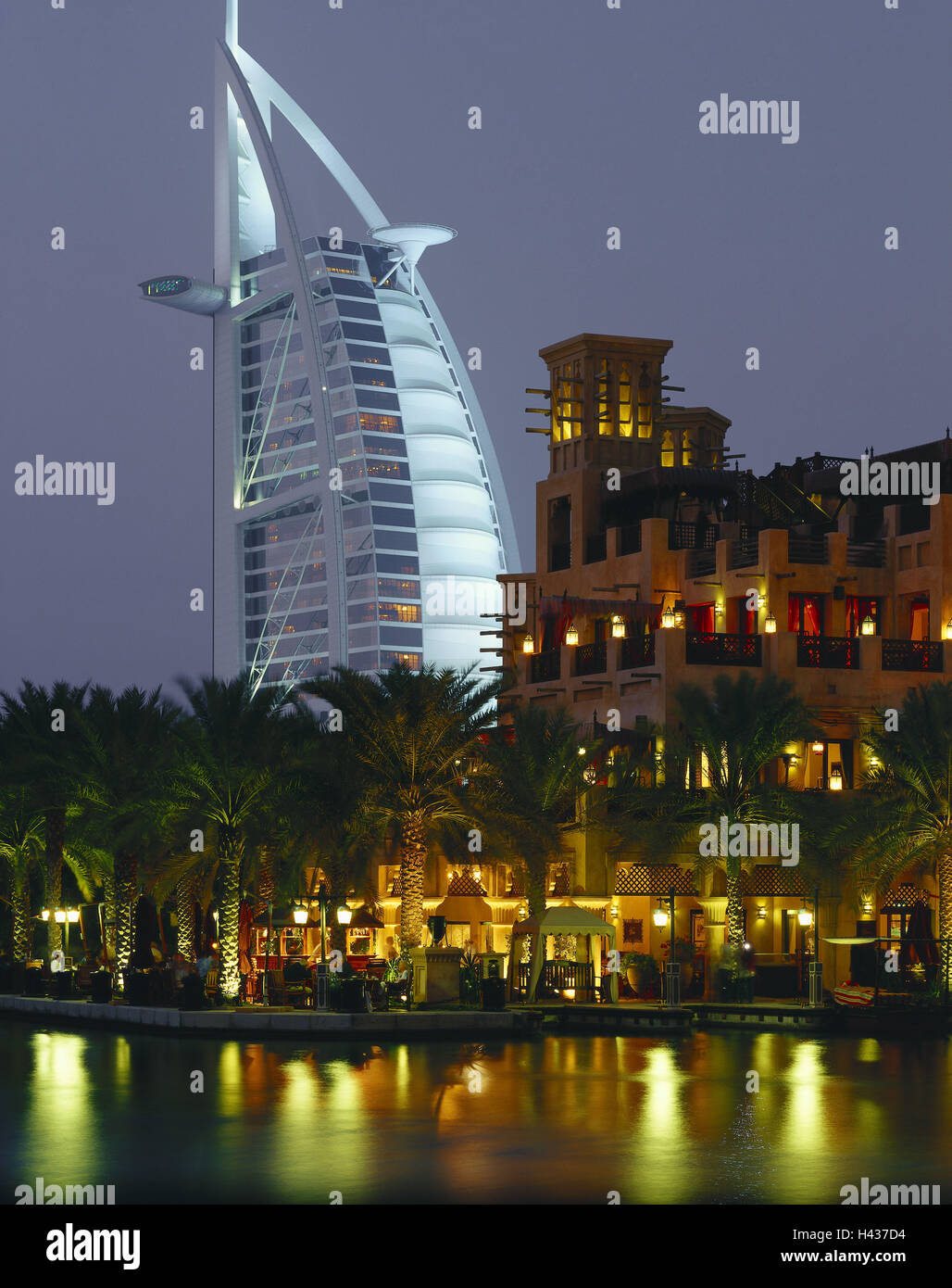 United Arab Emirates, Dubai, Madinat Jumeirah, hotel Burj Al Arab, restaurants, dusk, lighting, VAE, town, architecture, hotel, form, sail-like, building, hotel, landmark, structure, architectural style, modern, architecture, sail-like, luxury, five-star hotel, dream hotel, wealth, harbour, water, mirroring, lights, evening, vacation, tourism, palms, Stock Photo