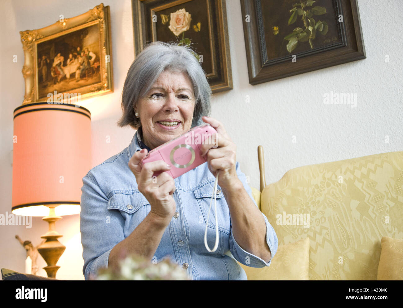Senior, game console, play, there, smile, people, woman, pensioner, PSP, console, Gameboy, pink, memory, memory training, brain jogging, concentration, flat, standard lamp, lighting, portrait, Stock Photo