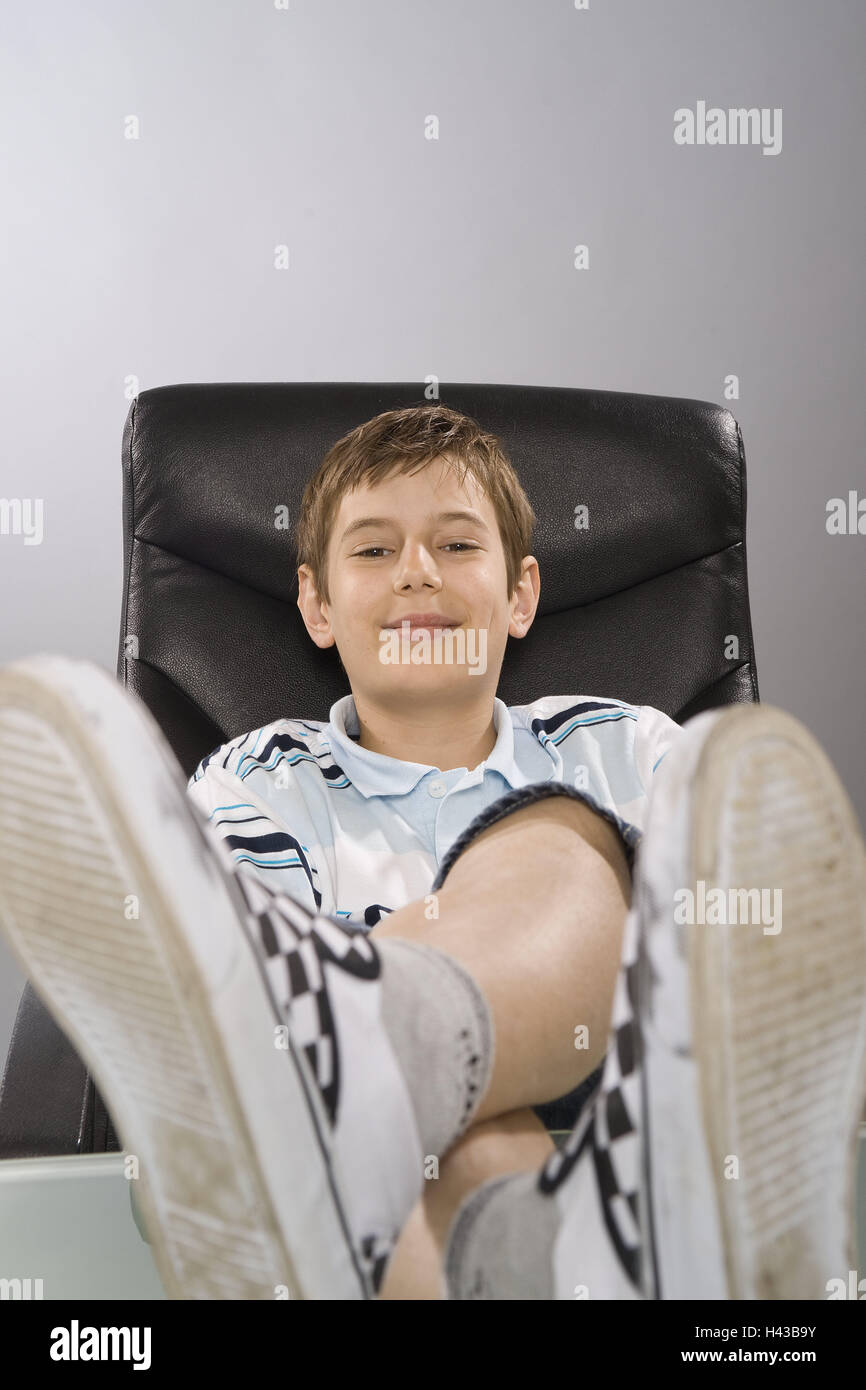 Teenagers, boy, leather chair, sit, feet, put up, look into camera
