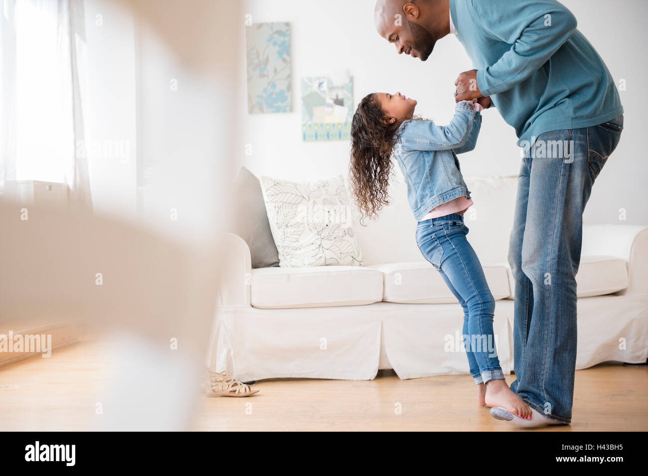 Daughter standing on feet of father and dancing Stock Photo