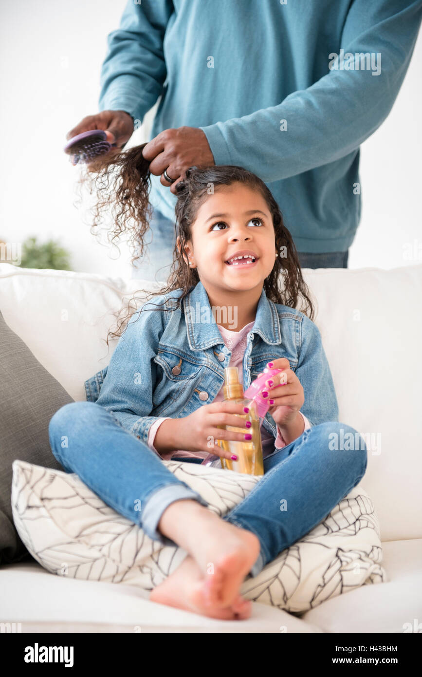 Father brushing hair of daughter Stock Photo